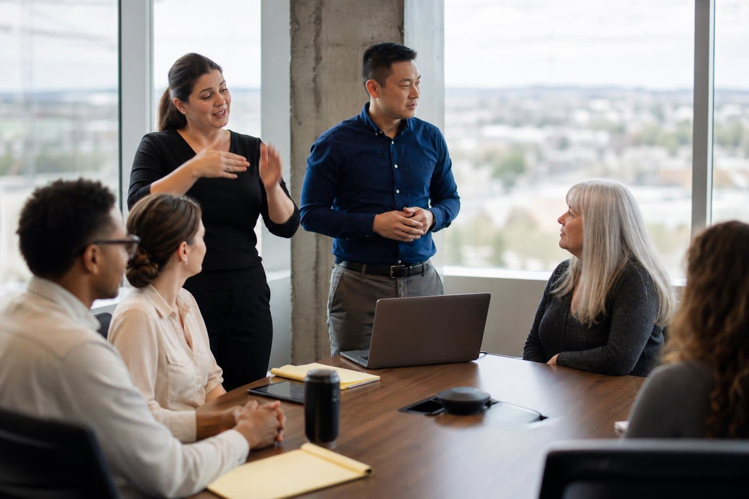 An ASL interpreter signing for a Deaf employee during a workplace meeting