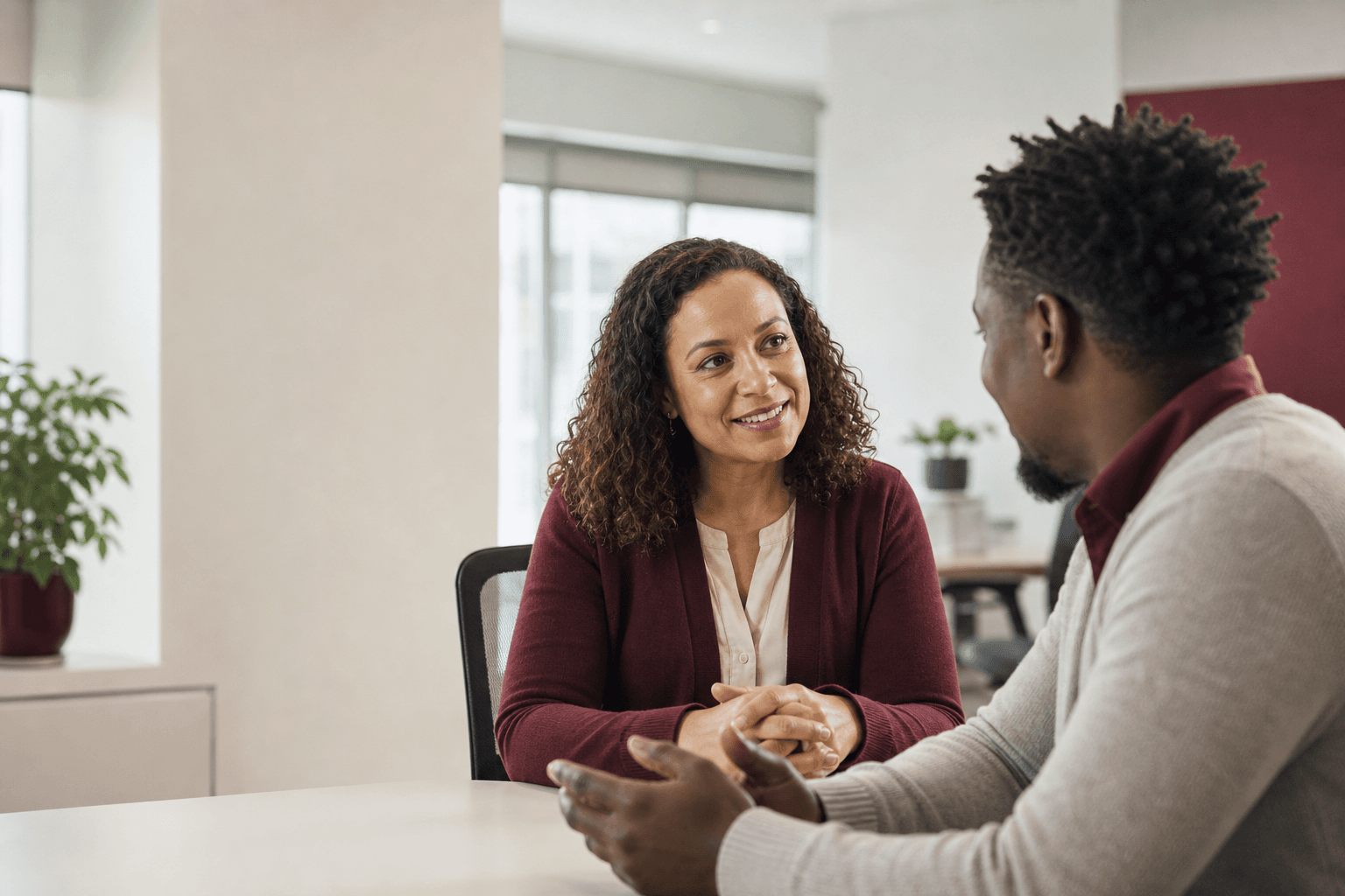 Human resources professional speaking with a Haitian employee in a workplace office