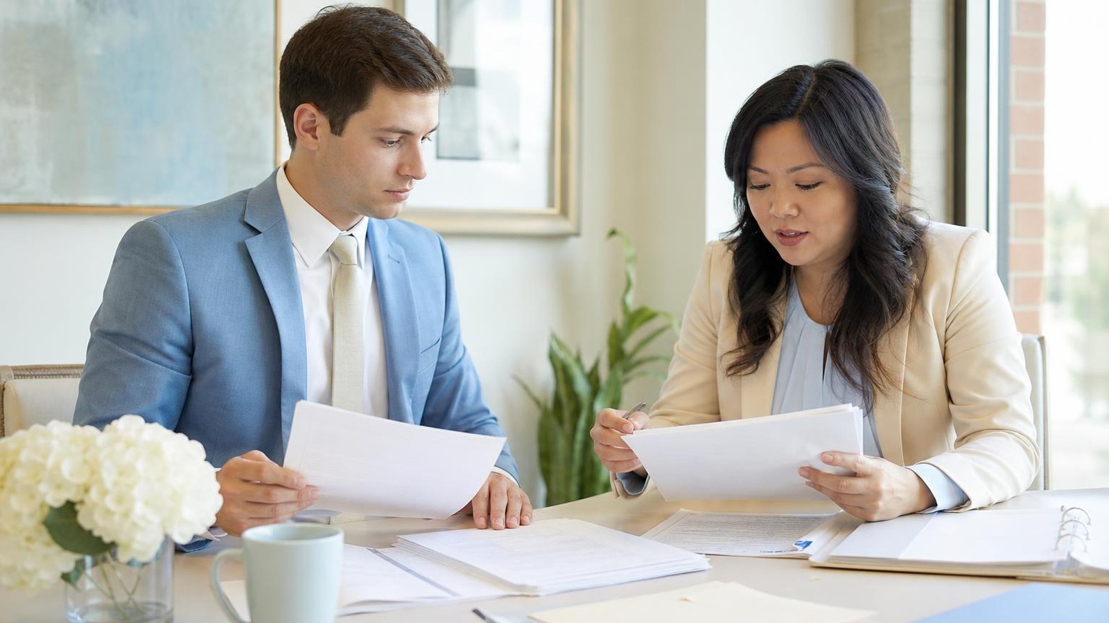 Attorney and language professional organizing multilingual legal documents for careful translation and case intake review